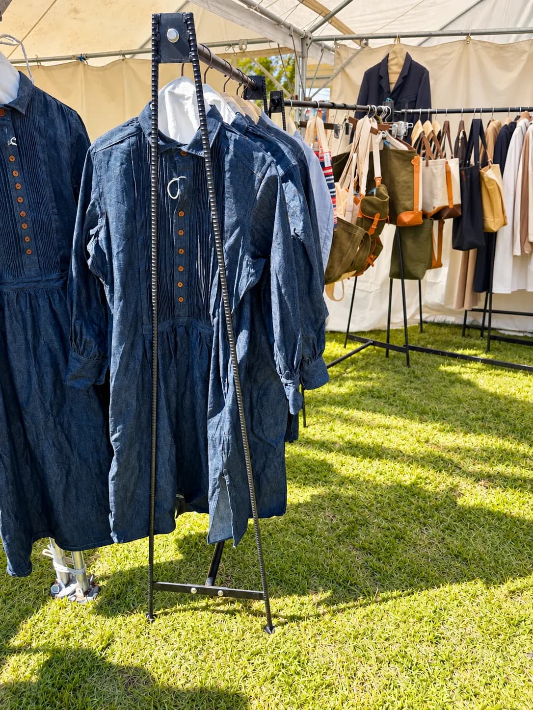 デニムの服と、帆布のバッグが並ぶテント。