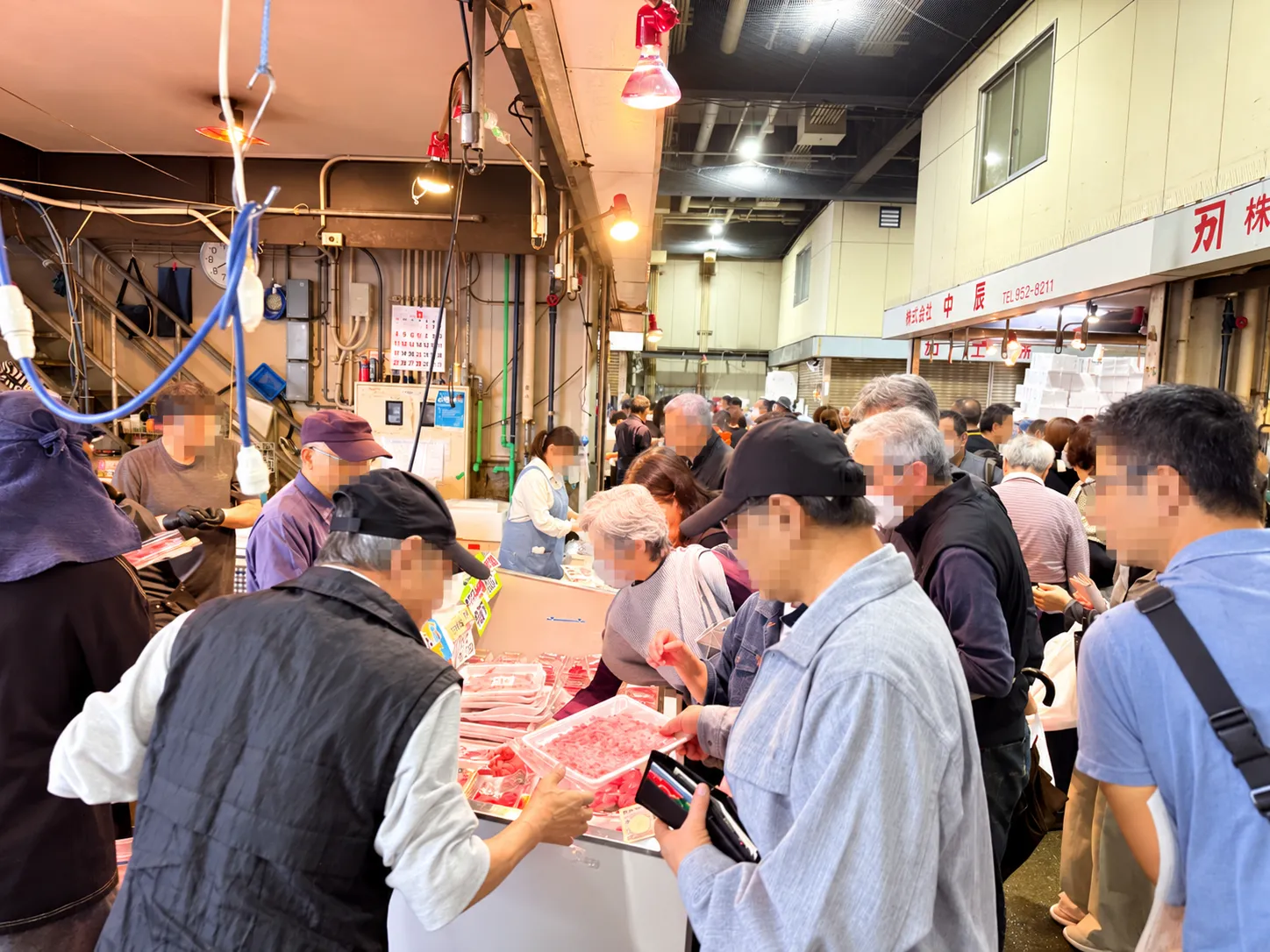 朝の市場はこの熱気。仲卸のお店の前に人が集まります。