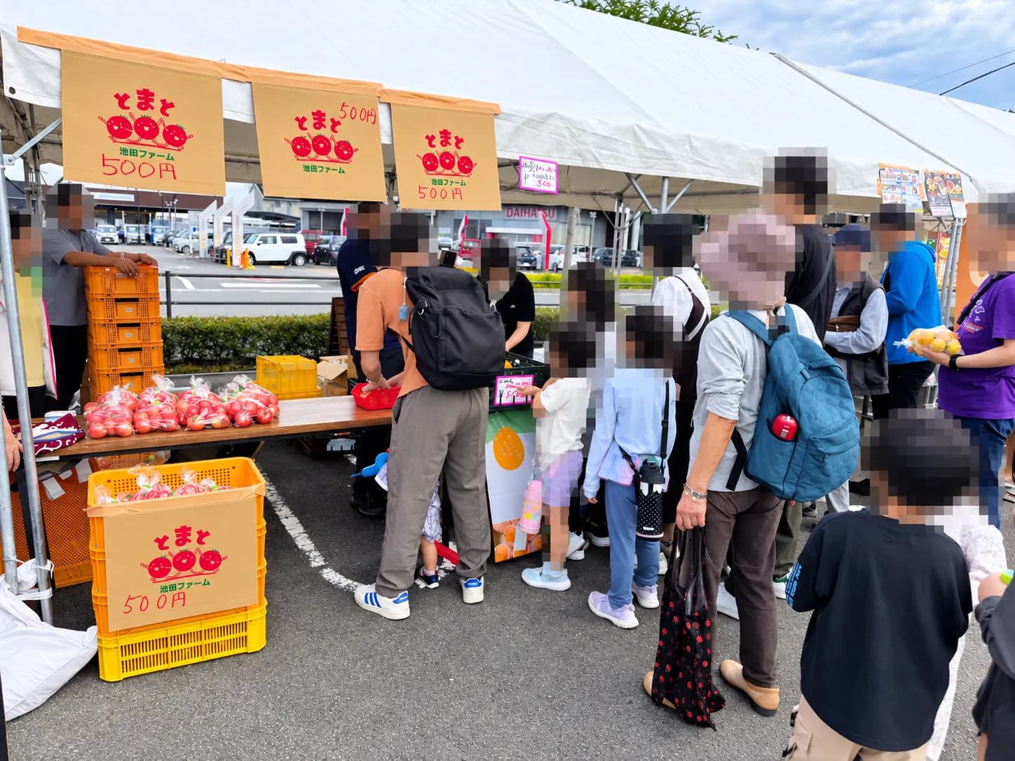トマトのテントには人だかり。「とまと500円」の札が並びます。