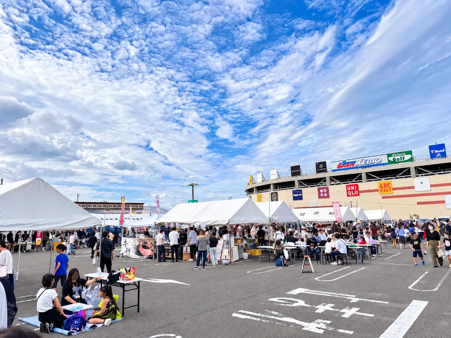エミフルMASAKIを背に、テーブル席で食事を楽しむ人たち。手前では子どもたちが遊んでいます。