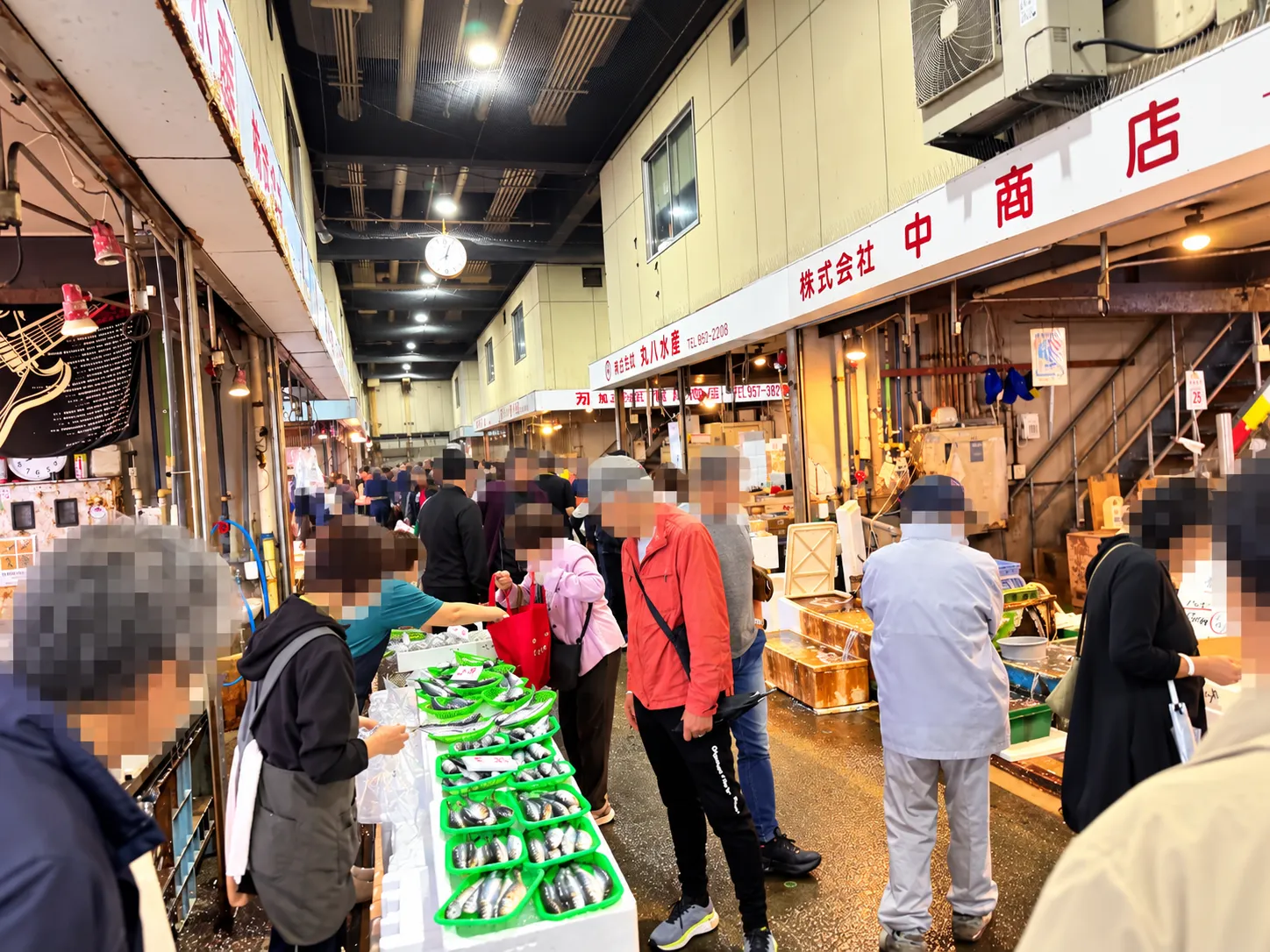 三津の朝市の日の魚市場のアーケード。仲卸のお店が並ぶ通路に、奥まで多くの人が集まる様子